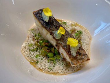 Gourmet Aşçılık Sanatında Kızarmış Balığın Zarif Güzel Yemek Sunumu Kıtır Deri, Yenilebilir Çiçekler ve Köpüklü Çorba