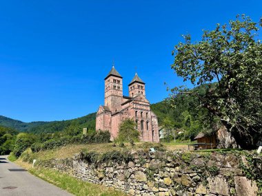 Florival, Haut-Rhin, Alsace, Fransa 'da Guebwiller yakınlarında berrak mavi bir gökyüzü altında Roma mimarisi ile çevrili tarihi Abbaye de Murbach manzarası