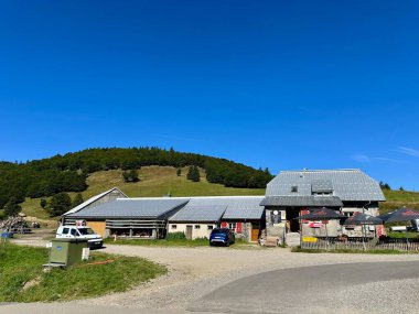 Lautenbach-Zell, Fransa - 11 Ağustos 2024: Col du Haag 'daki Ferme Auberge' in yeşil tepelere ve Alsace 'deki kırsal yaşamı ön plana çıkaran açık mavi gökyüzüne karşı kırsal mimarisi ile yakın plan