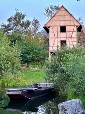 Bereketli Yeşilliğe gömülmüş Tahta kayıklı Huzurlu Göl kenarındaki Kırsal Keresteli Ev