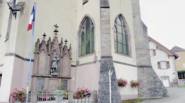 Lautenbach-Zell, Fransa - 21 Ağustos 2024: Sengern 'deki Saint-Nicolas Kilisesi, Sahne Alsas Mimarisi, Kule Saat Kulesi, Fransız Bayrağı ve Sunset' teki Picturesque Surround