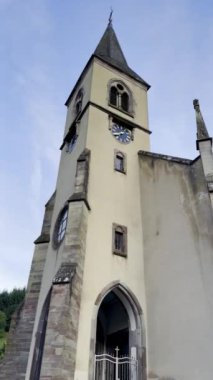 Sengern 'deki Saint-Nicolas Kilisesi, Lautenbach-Zell, Sahne Alsas Mimarisi, Yüksek Saat Kulesi, Fransız Bayrağı ve Fransa' nın Haut-Rhin kentindeki Sunset, Alsace kentindeki Picturesque Surroundings