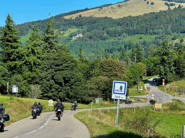 Soultz-Haut-Rhin, Fransa - 30 Ağustos 2024: Yeşil Tepeler ve Vosges Dağları, Alsace 'taki Ormanlar ve Çevresel Yol' da Birbirlerini Sürüp Selamlayan Motosikletliler Grubu