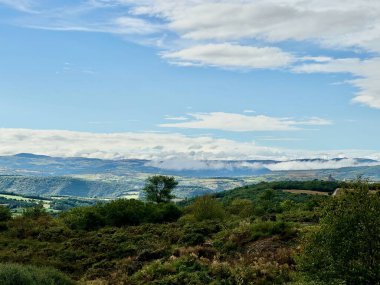 Expansive View of Rolling Hills and Verdant Valleys in Auvergne-Rhone-Alpes from Aire de Lafayette Lorlanges, Highlighting Lush Vegetation and Dramatic Cloudscapes Along the A75 Motorway clipart