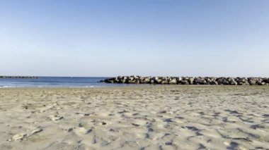 Kumsalda dinlenirken, ayaklar görünürde, Huzurlu Deniz manzaralı ve Fransa 'nın Carnon şehrinde açık mavi gökyüzü