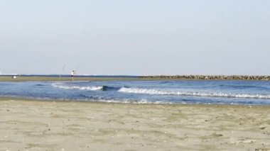 Carnon, Fransa - 26 Eylül 2024: Sahil kenarında sakin dalgalar ve sakin denizle ıssız bir balıkçı, Huzurlu bir Öğleden Sonra 'nın tadını çıkarıyor