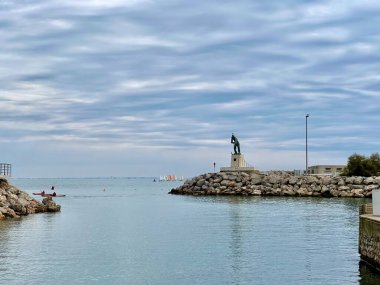 Palavas-les-Flots, Fransa - 26 Eylül 2024: Limandaki Balıkçı Heykeli, Anıtlı Kıyı Sahnesi, Sakin Sular ve Bulutlu Bir Gün Yelkenlilerine Haraç