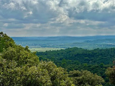 Verdant Plains ve Forested Hills 'in geniş bir manzarası Horizon' a uzanır Moody Bulutuyla kaplı Gökyüzü Pic Saint-Loup, Güney Fransa