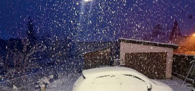 Intense Evening Snowfall Covering a Suburban Backyard, Car, and Garage Illuminated by Streetlights in Winter Atmosphere clipart