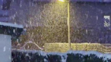 Şiddetli kar yağışı ile geçen kış gecesi sokak lambasıyla aydınlatılarak karlı bir şehir ortamında sıcak ve büyülü bir atmosfer yaratıldı.