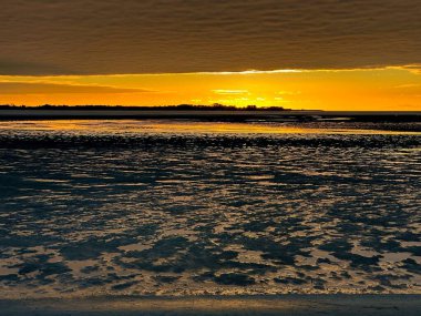 Ekim ayında Somme Körfezi 'ne yansıyan canlı günbatımı, Altın Parıltıyı yakalamak, Gelgit desenleri dalgalanması ve Le Crotoy' dan dramatik bir Horizon.