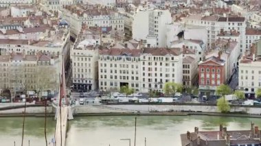 Lyon, Fransa - 23 Mart 2025: Modern gökdelenlerin ve tarihi çatıların siluetleri ile Lyon şehrinin üzerinde geniş panoramik gündoğumu manzarası, bulutlarla dolu bir gökyüzünün altında Fourviere tepesinden görüldü.