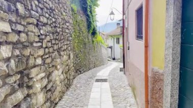 Como, İtalya - 3 Mayıs 2025: Ossuccio ve Lenno 'nun tarihi köylerinde taş duvarlar, kemerler, balkonlar ve Akdeniz cazibesiyle dar sokaklar ve renkli eski evler