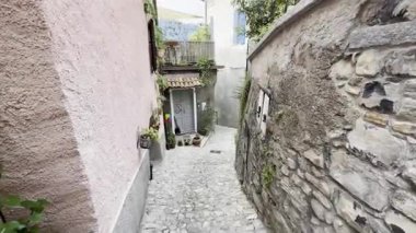 Como, İtalya - 3 Mayıs 2025: Ossuccio ve Lenno 'nun tarihi köylerinde taş duvarlar, kemerler, balkonlar ve Akdeniz cazibesiyle dar sokaklar ve renkli eski evler