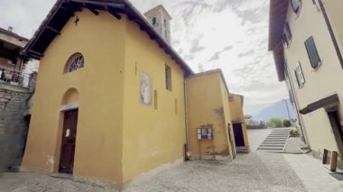 Como, İtalya - 3 Mayıs 2025: Ossuccio ve Lenno kırsallarındaki geleneksel kiliseler ve çan kuleleri, Romanesk ve Rönesans mimarisi ile yazın açık mavi gökyüzü altında