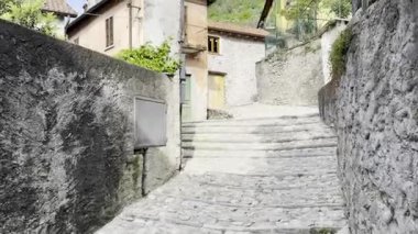 Como, İtalya - 3 Mayıs 2025: Ossuccio ve Lenno 'nun tarihi köylerinde taş duvarlar, kemerler, balkonlar ve Akdeniz cazibesiyle dar sokaklar ve renkli eski evler