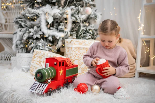 Menina Pijama Brincando Com Trem Retro Vermelho Sob Árvore Natal — Fotografia de Stock