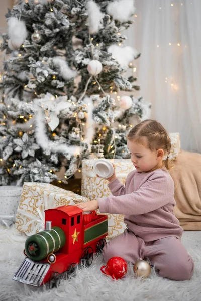 Menina Pijama Brincando Com Trem Retro Vermelho Sob Árvore Natal — Fotografia de Stock