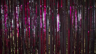 Pembe ışıkla süslenmiş gümüş yağmur. Parlak gümüş parıltılı ışıltılarıyla güzel gümüş bir arka plan. Şenlik havası. Noel ya da tatil teması. - Evet. Yüksek kalite 4k görüntü