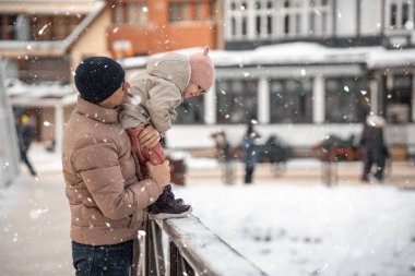 Genç baba ve kızı, Çek Cumhuriyeti 'nin küçük bir kasabasında karlı kış gününde eğleniyorlar. Yüksek kalite fotoğraf