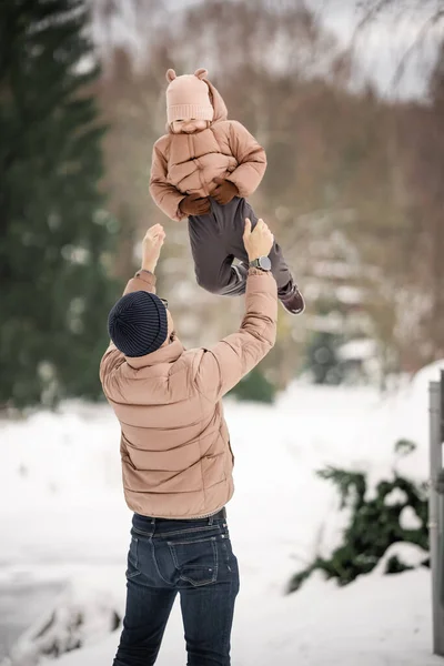 Handsome young dad and his little cute daughter are having fun outdoor in winter. Enjoying spending time together. Family concept. High quality photo