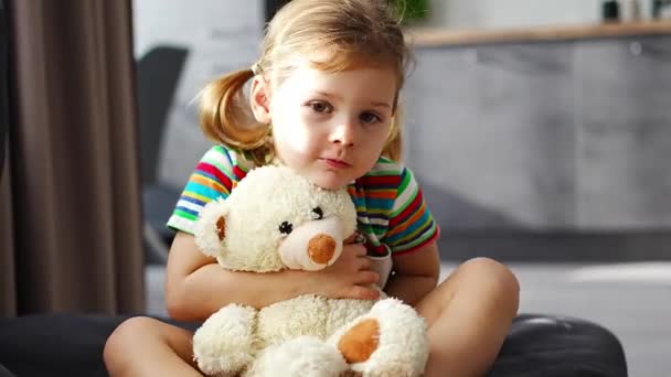 Nettes Kleines Mädchen Umarmt Teddybär Während Hause Auf Dem Sofa — Stockvideo
