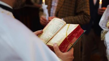 Prague, Czech Republic - February 2, 2023: Priest conducts the christening ceremony in church Cathedral of St. Clement in Prague, Czech republic. High quality 4k footage