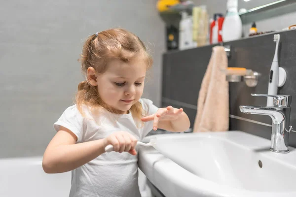 Happy toddler brushing teeth in the bath. High quality photo