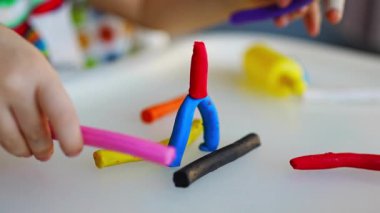 Küçük kız çok renkli plastiklerle oynar, farklı şekiller yaratır. Yüksek kalite 4k görüntü