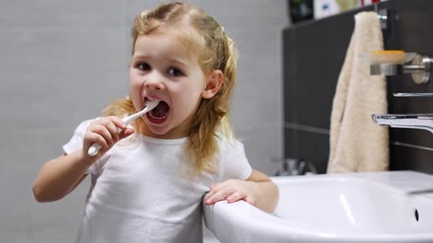 快乐的蹒跚学步的小女孩在浴室里刷牙 高质量的4K镜头 — 图库视频影像