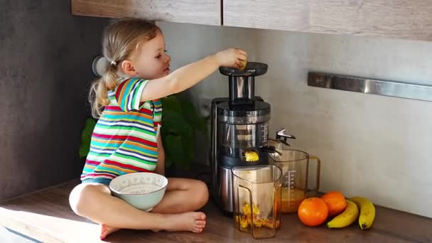 Κοριτσάκι Κάνει Φρέσκο Χυμό Κάθεται Στο Τραπέζι Στην Κουζίνα Του — Αρχείο Βίντεο