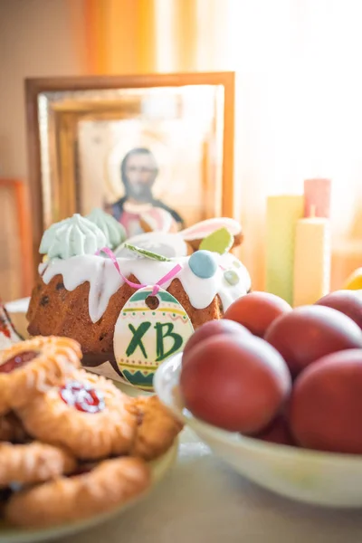 家庭のキッチンでテーブルの上に描かれた卵 リンゴ クッキーとイースターケーキ 教会のアイコンやキャンドルを背景に 正教会のテーマ 高品質の写真 — ストック写真