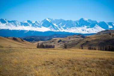 Karlı ve buzullu güzel dağ zirveleri, mavi gökyüzü ve Rusya 'nın Altai kentindeki güneş ışığında vadi manzarası. Yüksek kalite fotoğraf