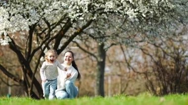 Genç anne ve tatlı kızı Prag, Avrupa 'daki bahar zamanı parkında eğleniyorlar. Yüksek kalite 4k görüntü