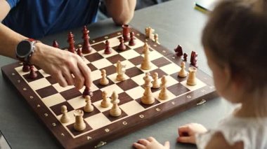 Baba küçük kızına evde mutfakta satranç oynamayı öğretiyor. Erken çocukluk gelişimini ve eğitimini hesaba katın. Aile eğlencesi, iletişim ve eğlence. Yüksek kalite 4k görüntü