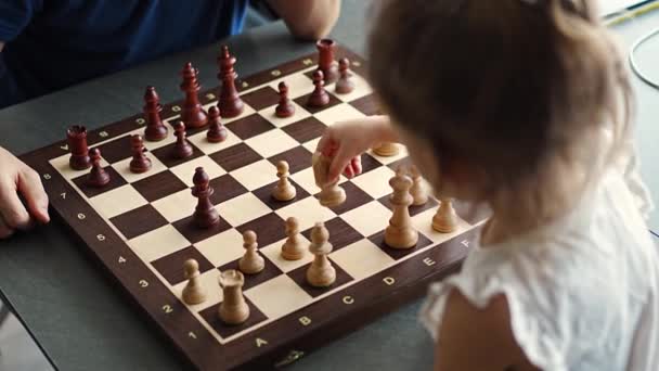 小女孩和她的父亲在家里厨房的桌子边下棋 幼儿发展和教育的概念 家庭休闲 交流和娱乐 高质量的4K镜头 — 图库视频影像