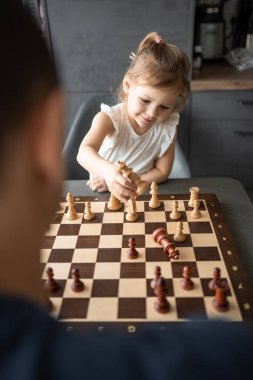 Baba küçük kızına evde mutfakta satranç oynamayı öğretiyor. Erken çocukluk gelişimi ve eğitim kavramı. Aile eğlencesi, iletişim ve eğlence. Yüksek kalite fotoğraf