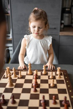 Baba küçük kızına evde mutfakta satranç oynamayı öğretiyor. Erken çocukluk gelişimi ve eğitim kavramı. Aile eğlencesi, iletişim ve eğlence. Yüksek kalite fotoğraf
