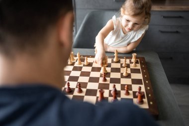 Baba küçük kızına evde mutfakta satranç oynamayı öğretiyor. Erken çocukluk gelişimi ve eğitim kavramı. Aile eğlencesi, iletişim ve eğlence. Yüksek kalite fotoğraf