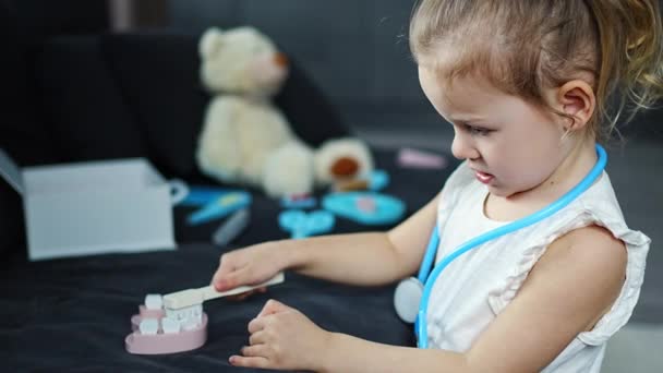 Evdeki Oturma Odasındaki Kanepede Tahta Oyuncaklarla Dişçilik Oynayan Küçük Kız — Stok video