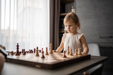 Baba küçük kızına evde mutfakta satranç oynamayı öğretiyor. Erken çocukluk gelişimi ve eğitim kavramı. Aile eğlencesi, iletişim ve eğlence. Yüksek kalite fotoğraf