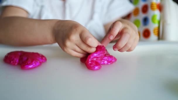 子供たちは家で粘菌おもちゃを遊んでいます 小さな女の子は自家製ピンクのスライムで遊んでいます 高品質4K映像 — ストック動画