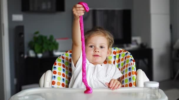 小女孩在玩一种自制的粉色黏液 孩子们在家里玩泥巴玩具 高质量的4K镜头 — 图库视频影像