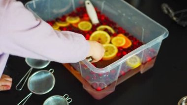 Küçük kız mutfak malzemeleri, böğürtlen ve narenciye ile el yapımı meyve barında oynuyor. Duyusal gelişim ve deneyimler, çocuklarla ilgili temalı aktiviteler, iyi motor beceriler geliştirme.