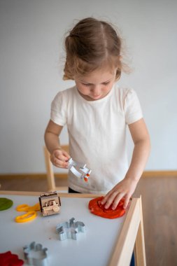 Küçük bir kız plastikle oynuyor. Duyusal gelişim ve deneyimler, çocuklarla ilgili temalı aktiviteler, iyi motor beceriler geliştirme. Yüksek kalite fotoğraf