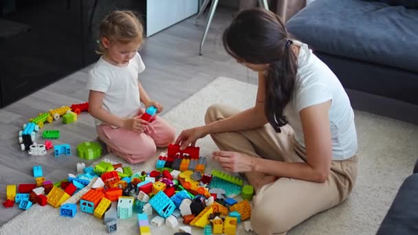 Menina Brincar Com Brinquedo Construtor Chão Casa Com Mãe Mulher — Vídeo de Stock