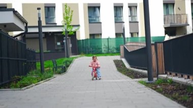 Prag, Avrupa 'daki konutun avlusunda bisiklete binen küçük bir kız. Yüksek kalite fotoğraf