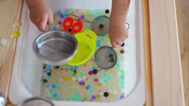 小女孩玩感官水珠 水凝胶球 感官发展和经验 与儿童的主题活动 精细的运动技能发展 高质量的4K镜头 — 图库视频影像