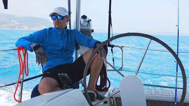 年轻的船长在海上航行时掌舵 控制着帆船 高质量的4K镜头 — 图库视频影像