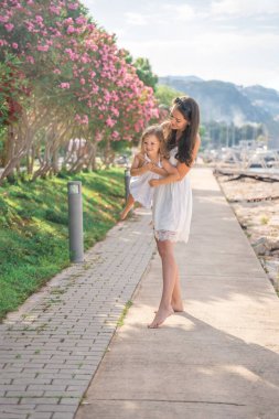 Mutlu anne-kız çocuğu marinada lüks yatlarda eğleniyor. Aile seyahati, yaşam tarzı, tatil konsepti. Yüksek kalite fotoğraf